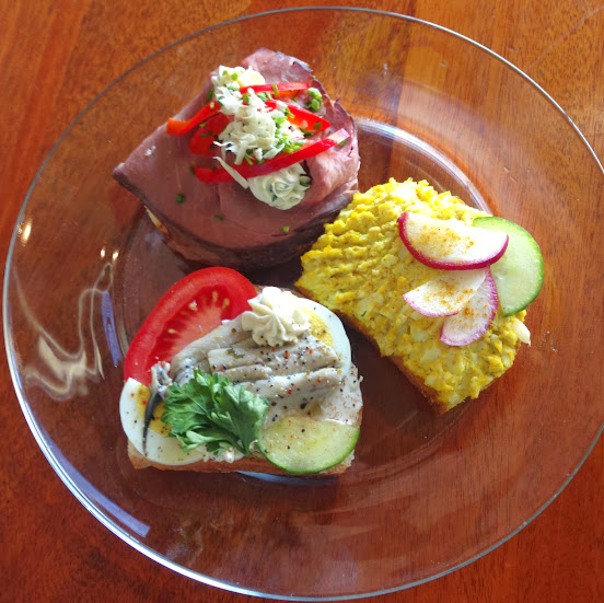 Sandwich trio: Spanish boquerone with puta spread, egg, cucumber, tomato; curry egg salad with cucumber and radishes; and roast beef with chive cream cheese, roasted red peppers, chives, and horseradish
