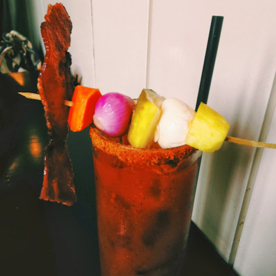 Bourbon Bloody Mary with Stu’s mix, Benchmark bourbon, bacon, and pickled quail egg