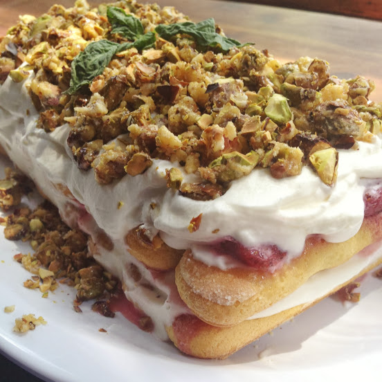 Cake with basil, cream, roasted strawberries, ladyfingers, and pistachios