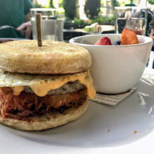 Gas station sandwich with hashbrown, egg, cheese, grape jelly, and sausage, served with Michigan-grown fruit