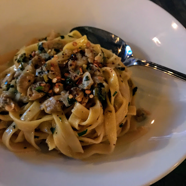 Linguine and clams with egg yolk linguine, briny clams, charred leek, and uni butter