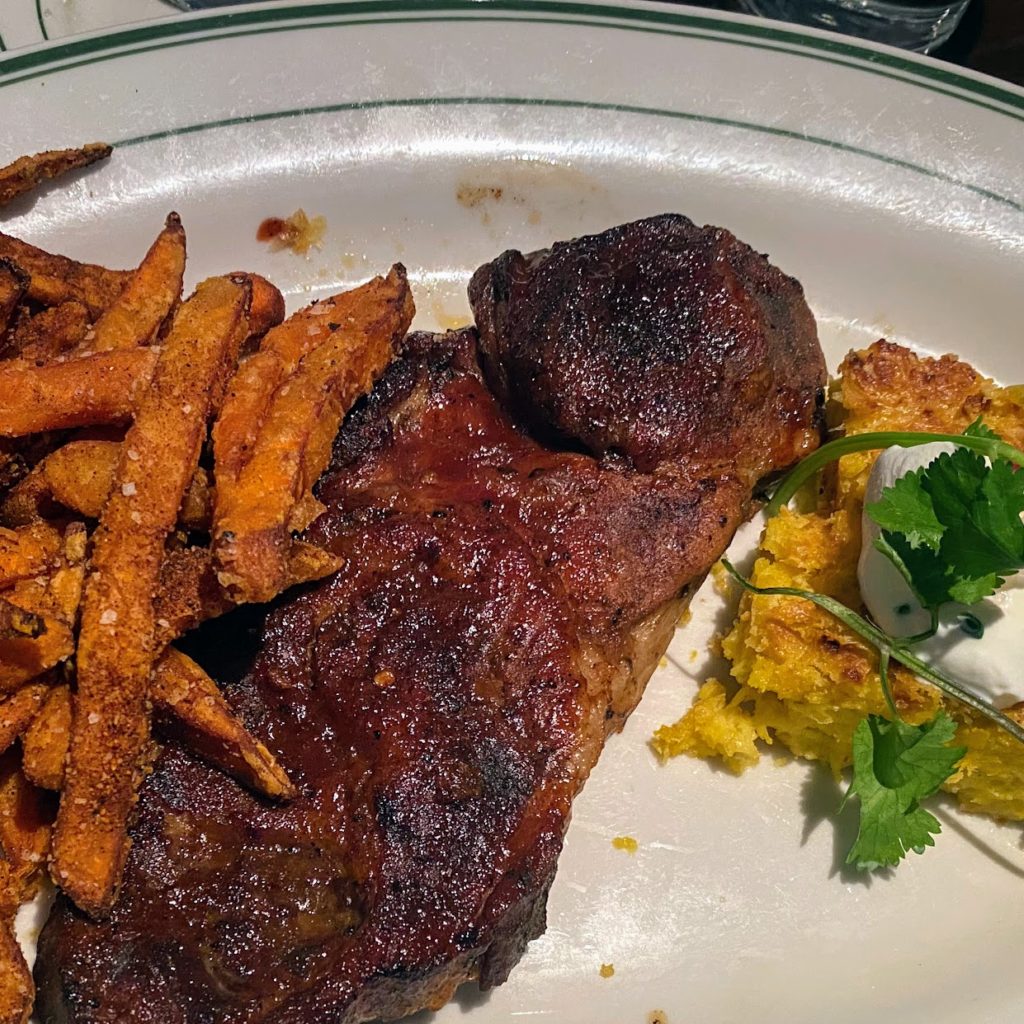 Boneless country pork rib with caramelized barbecue sauce, sweet potato fries, and corn pudding