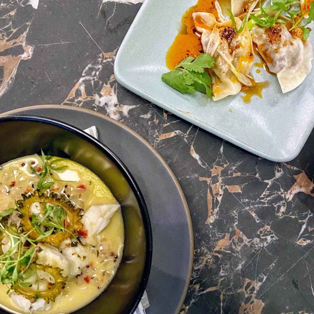 Steamed yellow curry custard with jumbo lump crab, curry leaf, and fried bitter melon; Szechuan-style braised lamb dumplings with chili crisp and scallions