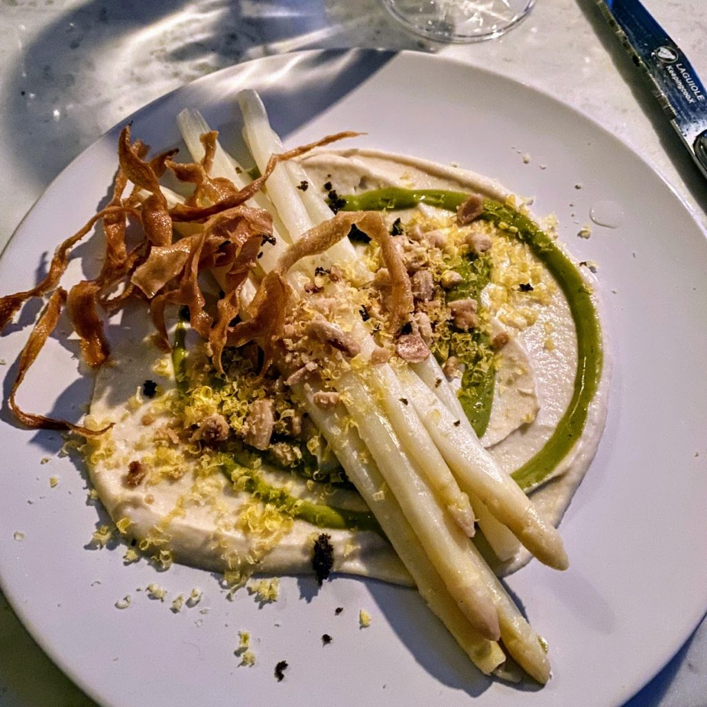 Poached white asparagus with smoked parnsip, watercress, marcona almond, caper dus, and cured egg yolk