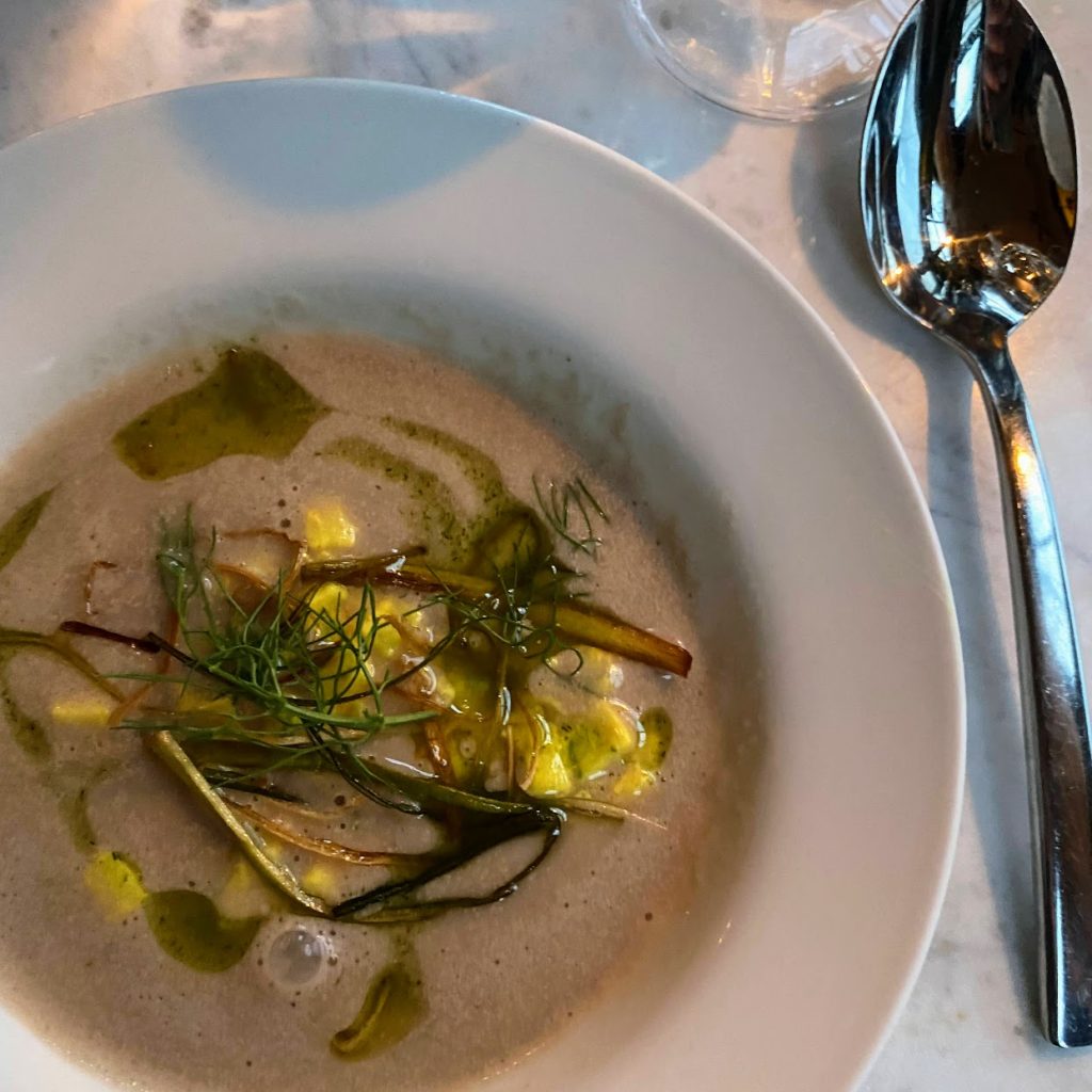 Fennel and walnut soup with apple, turmeric, black vinegar, and crispy leeks