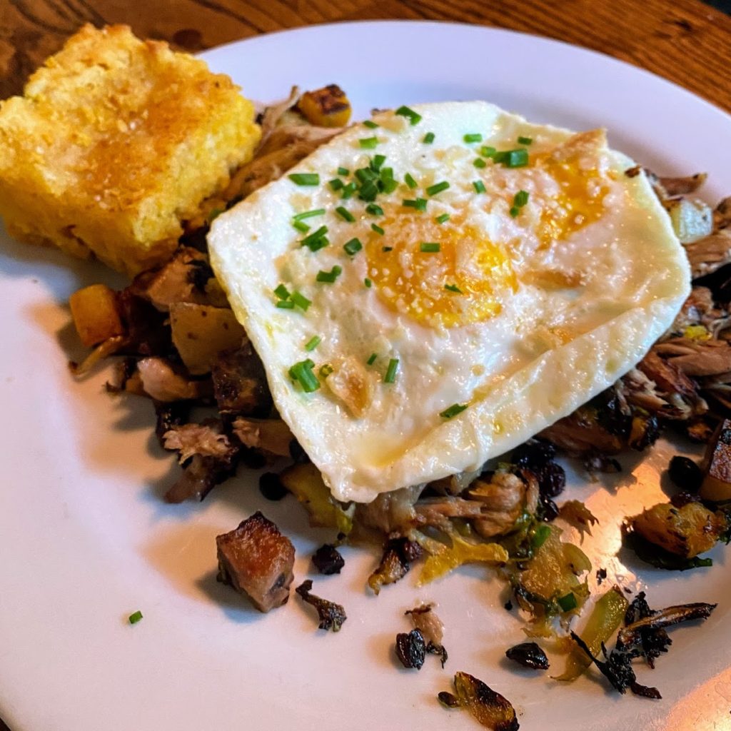 Dr. Joe’s duck hash with pulled roast duck, seasonal root vegetables, over-easy local farm eggs, duck crackling, and green onions with sweet potato biscuit, Nectar Farm Kitchen